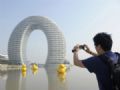 Hotel em forma de ferradura gigante abre ao pblico na China Homem fotografa o Sheraton Huzhou Hot Spring Resort, conhecido como Hotel Donut ou Hotel Ferradura (Foto: Sean Yong/Reuters)