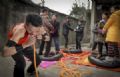 Homem com ''pulmes de ao'' enche pneus usando o nariz na China Nie Yongbing faz esforo para encher pneus com pessoas em cima usando o nariz, durante uma performance realizada em sua casa na China (Foto: Stringer/Reuters)