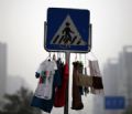 Placa de trnsito se torna ''varal'' com roupas penduradas em rua na China Placa em Pequim, na China, se tornou varal ao ter roupas penduradas para secar (Foto: Kim Kyung-Hoon/Reuters)