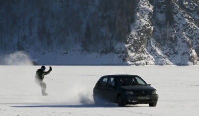 Russo pratica snowboard puxado por carro na superfcie congelada de rio Russo praticou snowboarding puxado por carro na superfcie congelada do rio Yenisei (Foto: Ilya Naymushin/Reuters)