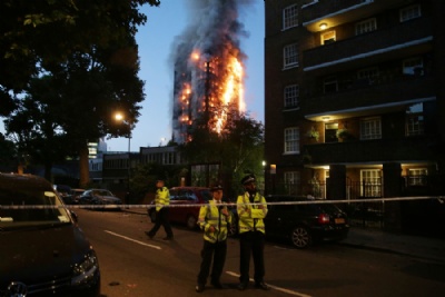  Incndio atinge prdio de 24 andares e deixa 12 mortos em Londres Policiais isolam rea prxima ao prdio em chamas durante o amanhecer em Londres (Foto: Daniel Leal-Olivas/AFP) 